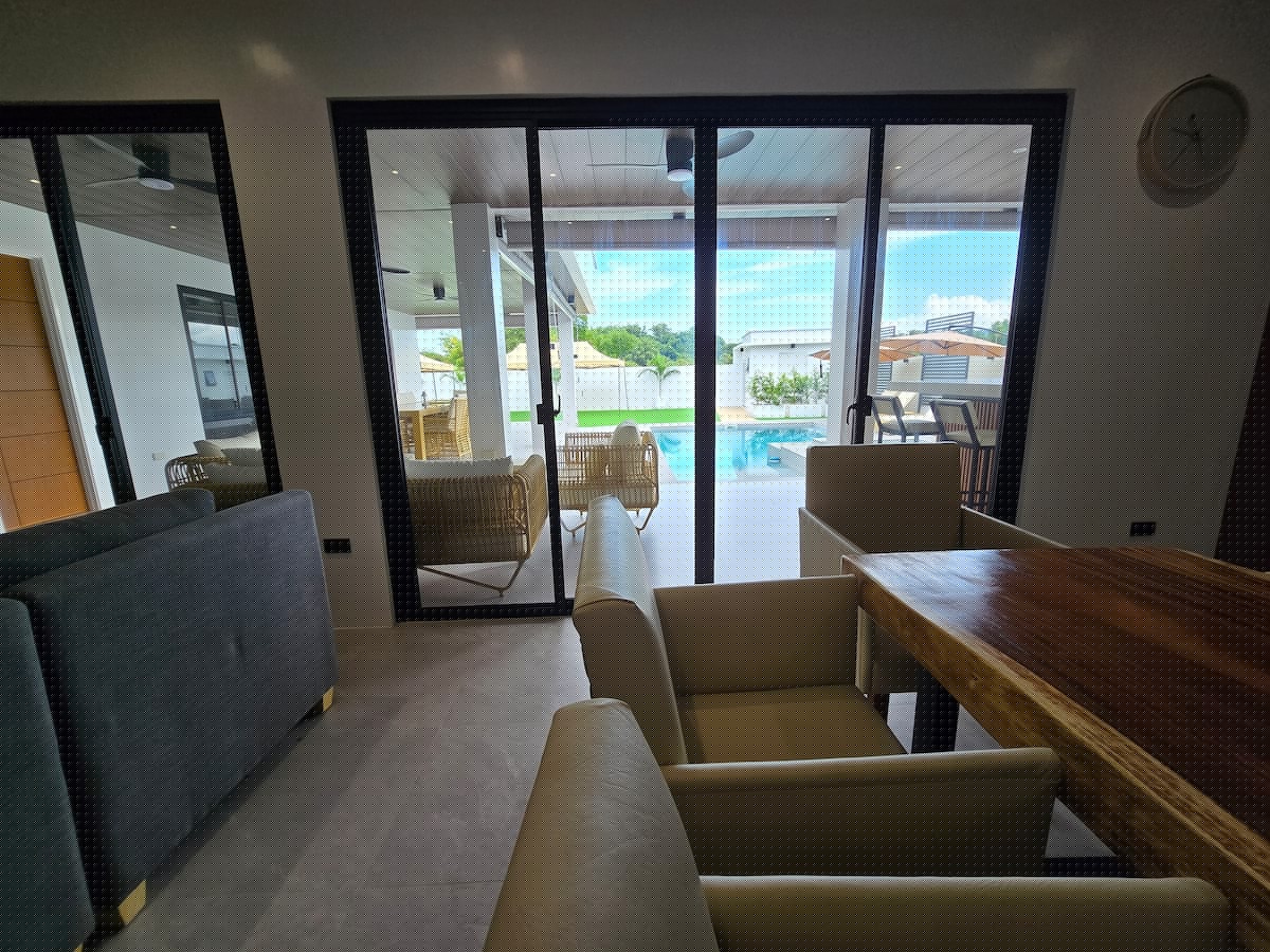 Living room view through glass sliding doors to pool terrace